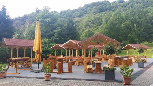 a pavilion with tables and a yellow umbrella at Moselhotel Waldeck in Burgen