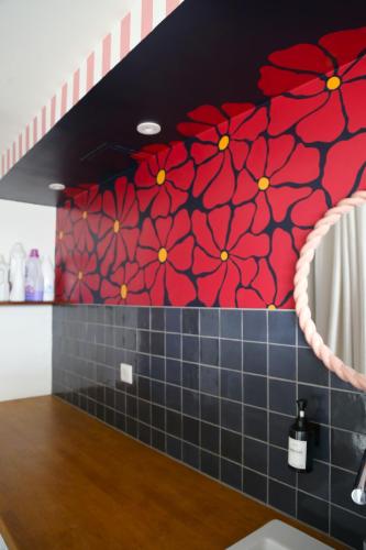 a kitchen with red flowers painted on the wall at Stripe Studio in Bonne-sur-Ménoge