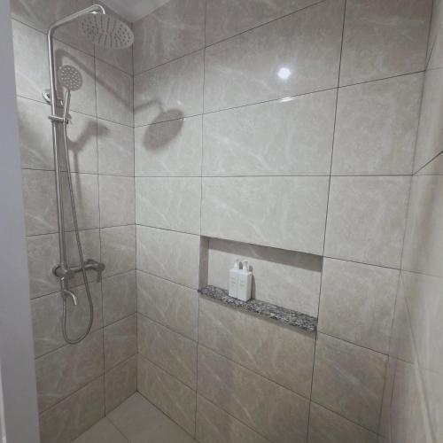 a bathroom with a shower with a glass door at Sunflower Residences Capitol formerly mayflower inn in Cebu City