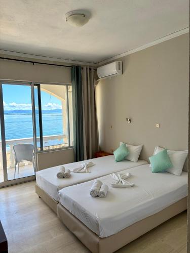a bedroom with two beds with a view of the ocean at IONIAN MARE in Agios Ioannis Peristerion