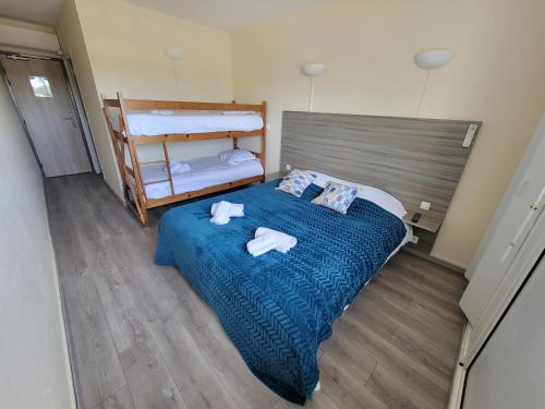 a bedroom with a bed with towels on it at Océan et Forêt in Les Mathes