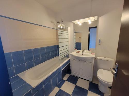 a bathroom with a toilet and a tub and a sink at Océan et Forêt in Les Mathes