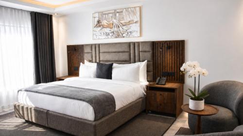 a hotel room with a bed and a chair at Regent Heights Hotel in Johannesburg