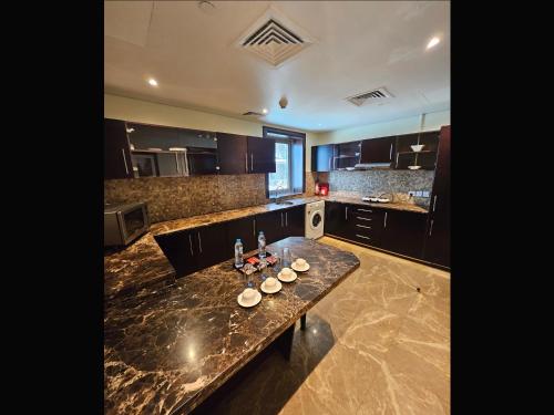 a kitchen with a marble counter top in a room at Tulip Creek Hotel Apartments in Dubai