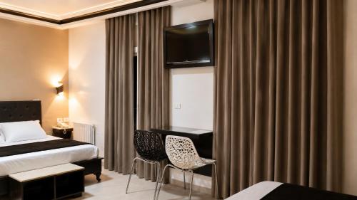 a hotel room with a bed and a desk at Hôtel le calife in Tunis