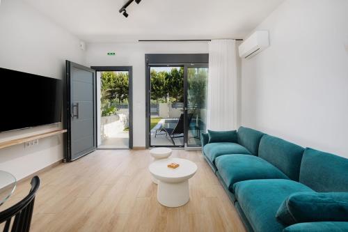 a living room with a blue couch and a tv at No7 Pool House in Iraklitsa