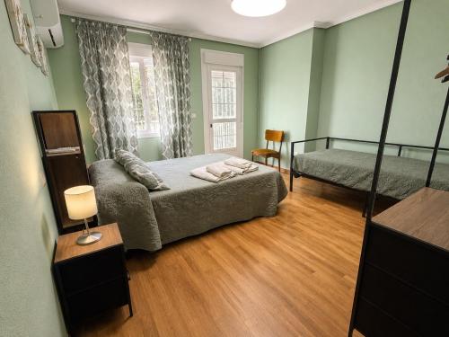 a bedroom with a bed and a couch and a window at CASA DOVELA in Jarandilla de la Vera