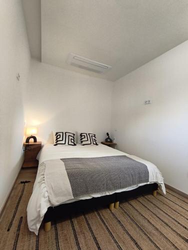 a white bedroom with a large bed with pillows at Cidral Path 32 in Póvoa de Varzim