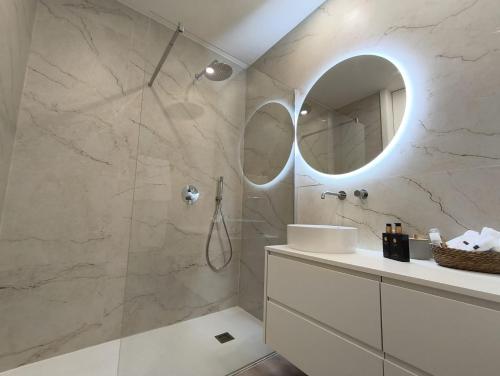 a bathroom with a shower with a sink and a mirror at Cidral Path 32 in Póvoa de Varzim