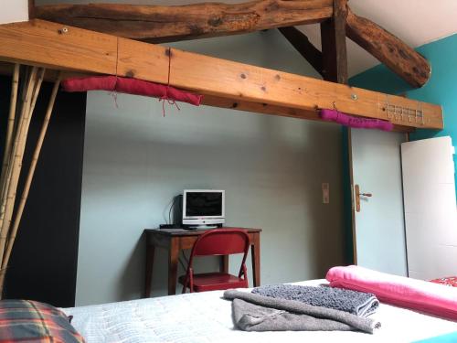 a bedroom with a bunk bed with a computer on a desk at Chambres chez l'habitant Bambou et Musique cuisine et sdb partagées in Saint-Sever