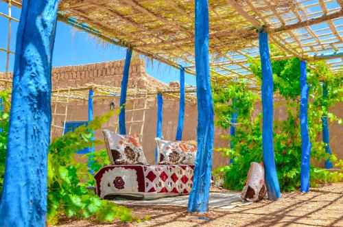 a couch with pillows sitting under a pergola at Kasbah Abdou in El Kelaa des Mgouna
