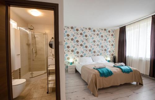 a bedroom with a bed and a bathroom with a shower at PATIO dom gościnny in Łukęcin