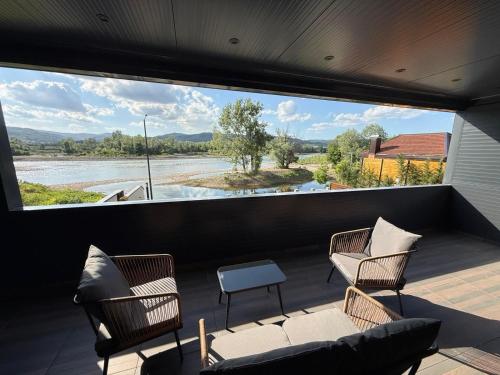 a balcony with chairs and a couch and a large window at AdDrinum in Gornja Koviljača