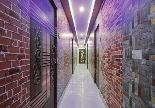 a hallway with a brick wall with a purple light at Hotel Pink City& Banquet in Dīgha