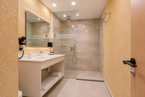 a bathroom with a sink and a shower at 3B Suites Boutique Hotel in Sarandë
