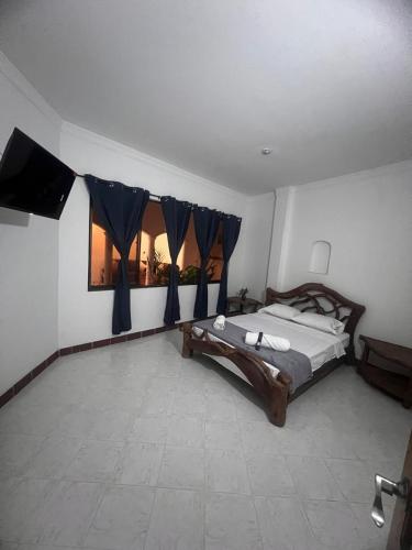 a bedroom with a bed with blue drapes at Casa Vacacional San Gil Santander in San Gil