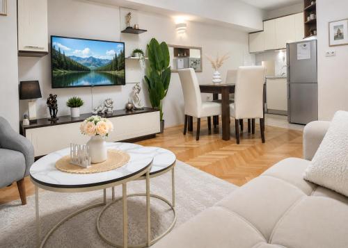 a living room with a table and a tv on a wall at Apartment 88 SELF check-in, FREE parking in Skopje