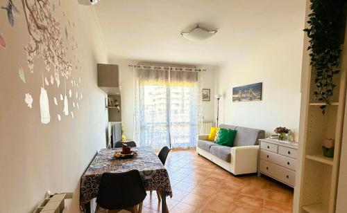 a living room with a table and a couch at NUOVO Alloggio Giardino di Rosy tra Roma EUR e il Mare di Ostia in Vitinia