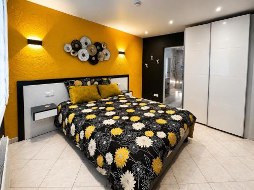 a bedroom with a bed with a black and yellow blanket at Gîte Autour d'Opale in Cucq