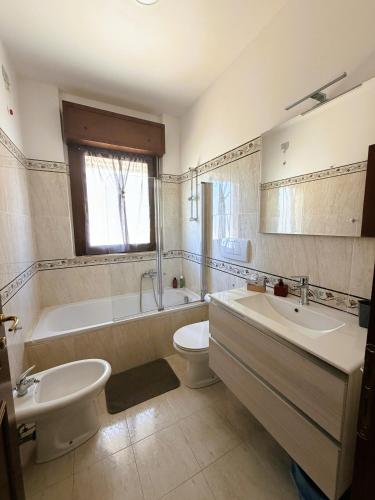 a bathroom with a tub and a toilet and a sink at NUOVO Alloggio Giardino di Rosy tra Roma EUR e il Mare di Ostia in Vitinia