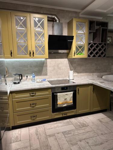 a kitchen with yellow cabinets and a stove top oven at Pearl KadoRR in Liski