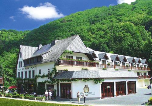 a large white building with people standing outside of it at Moselhotel Waldeck in Burgen