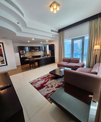 a living room with a couch and a table at Tulip Creek Hotel Apartments in Dubai