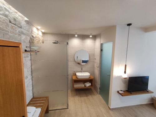 a bathroom with a sink and a toilet and a mirror at Villa Tholos Crete in Kavoúsion
