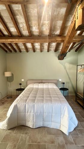a large white bed in a room with wooden ceilings at Casa Vacanze Partenzi in Vallo di Nera