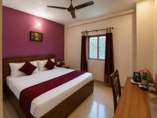 a bedroom with a bed and a table and a window at Hotel Akshni Palace in Pūrnia