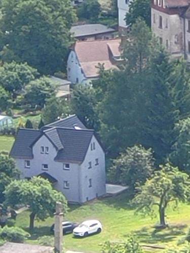 a large white house with cars parked in a field at Bobrowe zacisze in Wleń