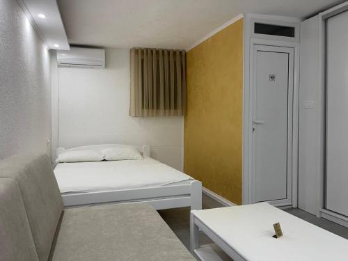 a small room with a bed and a table at Relax Apartmani in Sutomore