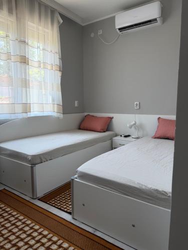 two beds in a room with a window at Apart Hotel Lyubimets in Lyubimets