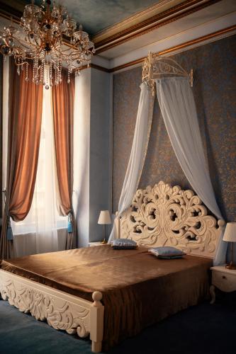 a bedroom with a large bed with a chandelier at Belle Epoque Boutique (Adult Only) in Constanţa