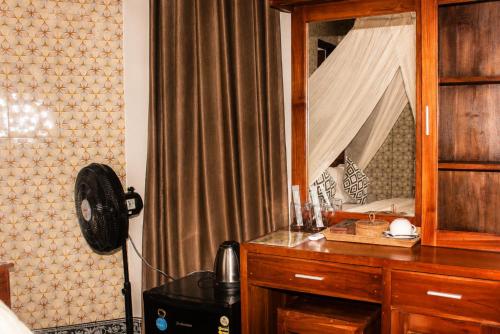 a bedroom with a desk with a phone and a mirror at Adyara Homestay in Sidemen