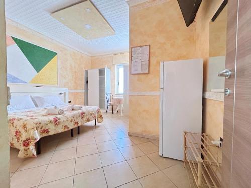 a bedroom with a bed and a refrigerator at Pensione Affittacamere Miriam in Scalea