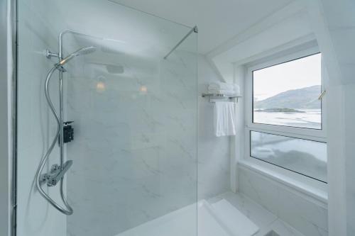 a white bathroom with a shower and a window at The Lochalsh Hotel - Isle of Skye in Kyle of Lochalsh