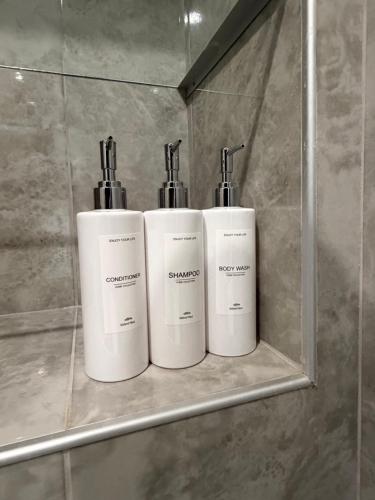 three bottles ofodorizers sitting on a shelf in a bathroom at Apart Hotel Lyubimets in Lyubimets