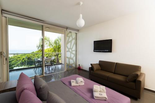 a living room with a couch and a television at WhiteLace Resort in Jbeil