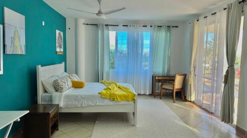 a bedroom with a bed with a yellow blanket on it at Mtwapa Beach Nest D3 in Mtwapa