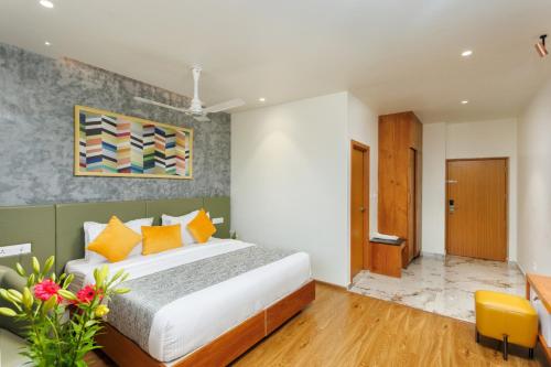 a bedroom with a large bed and a yellow chair at Meadows Residency in Ooty