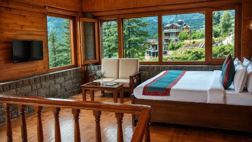 a bedroom with a bed and a tv and windows at 8fold by Larisa, Jibhi in Jibhi