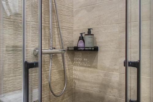 a bathroom with a shower with a soap bottle on a shelf at Lux PIGALLE in Argenteuil