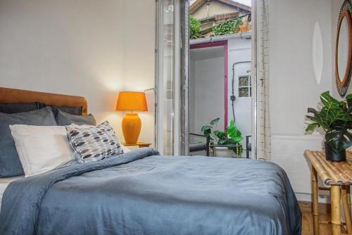 a bedroom with a bed with a blue blanket at Lux PIGALLE in Argenteuil