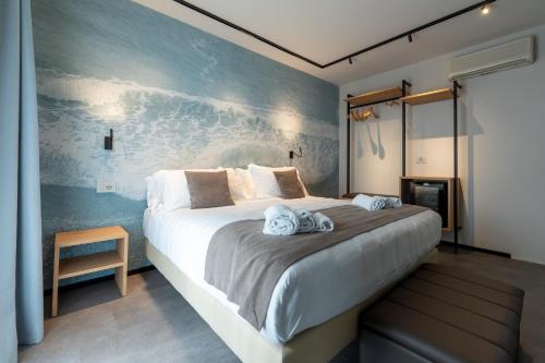 ein Schlafzimmer mit einem großen Bett und einer blauen Wand in der Unterkunft Spa Hotel Splendid Sole in Manerba del Garda
