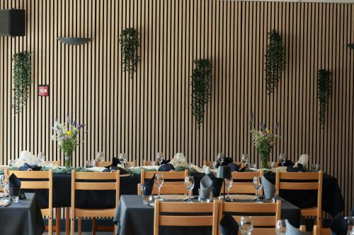 a dining room with tables and chairs and a wall at Le Shantoné in Saint-Michel-de-Maurienne