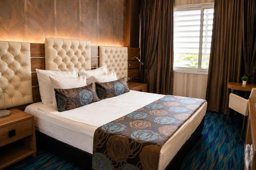 a hotel room with a large bed with a headboard at Orty Airport Hotel in İzmir