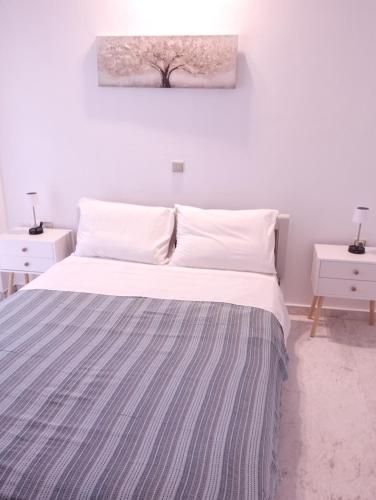 a bedroom with a bed with a striped blanket on it at Αλέξανδρος 4 in Myrina