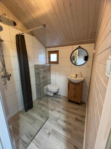 a bathroom with a toilet and a sink at Domki Na Skraju in Stegna