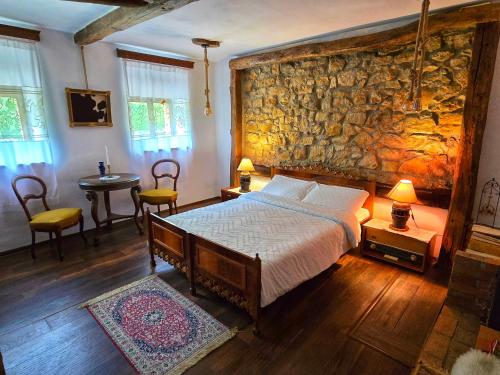 ein Schlafzimmer mit einem Bett und einer Steinwand in der Unterkunft CasaGeo Cheile Nerei in Socolari